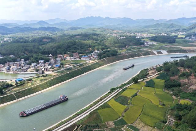 (261021) -- QINZHOU, Oct. 21, 2026 (Xinhua) -- An aerial drone photo taken on Oct. 21, 2026 shows cargo vessels on the Pinglu Canal in south China's Guangxi Zhuang Autonomous Region. Cargo throughput of the Pinglu Canal has surpassed 1 million tonnes since its opening to navigation on Sept. 16.
  The 134.2-kilometer canal runs from Nanning, capital of south China's Guangxi Zhuang Autonomous Region, to the Beibu Gulf, the closest maritime outlet for much of southwest China.
  The canal stretches along the New International Land-Sea Trade Corridor, a strategic trade route connecting China's inland regions with ASEAN and other global markets. It is the first river-to-sea canal project planned and coordinated at the national level since the founding of the People's Republic of China in 1949. (Xinhua/Zhou Hua)