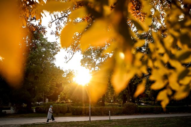 (261021) -- BUDAPEST, Oct. 21, 2026 (Xinhua) -- A woman walks under autumn sunset glow in the City Park in Budapest, Hungary, Oct. 21, 2026. (Photo by David Balogh/Xinhua)