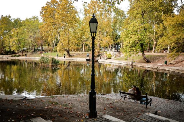 (261021) -- BUDAPEST, Oct. 21, 2026 (Xinhua) -- A couple sits on a bench by the lake in the City Park, Budapest, Hungary, Oct. 21, 2026. (Photo by David Balogh/Xinhua)