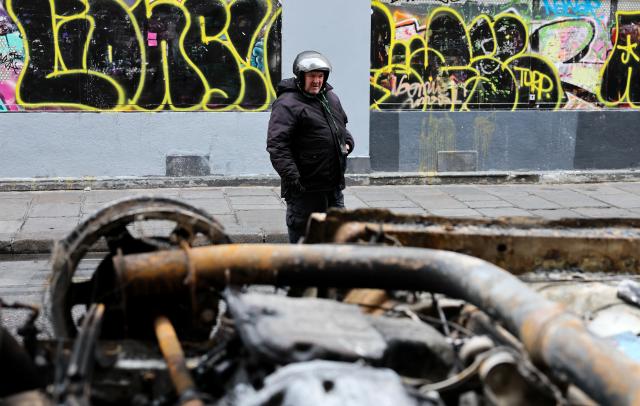 (261021) -- PARIS, Oct. 21, 2026 (Xinhua) -- A man watches vehicles destroyed by fire during the earlier demonstration on a street in Paris, France, Oct. 21, 2026. The French government has vowed to do everything within its power to prevent violence at fresh social demonstrations announced for Saturday, after riots around the country caused widespread destruction and thousands of arrests on Oct. 17. (Xinhua/Wu Huiwo)