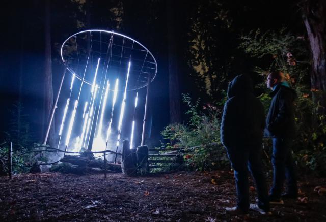 (261022) -- VANCOUVER, Oct. 22, 2026 (Xinhua) -- Visitors view illuminated installations during a preview of Astra Lumina at Stanley Park in Vancouver, British Columbia, Canada, on Oct. 21, 2026. Astra Lumina, an immersive outdoor night walk, will make its Canadian debut at Stanley Park on Thursday. The approximately 1.6-kilometer trail features nine themed zones where colorful light installations, projections and soundscapes transform the forest into a star-inspired nighttime experience. 
   The event runs from Oct. 22 to Dec. 31. (Photo by Liang Sen/Xinhua)