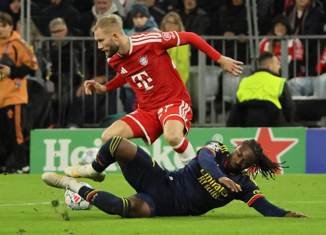 (261022) -- MUNICH, Oct. 22, 2026 (Xinhua) -- Konrad Laimer (top) of Bayern Munich vies with Eberechi Eze of Arsenal during the UEFA Champions League match between Bayern Munich and Arsenal in Munich, Germany, on Oct. 21, 2026. (Photo by Philippe Ruiz/Xinhua)