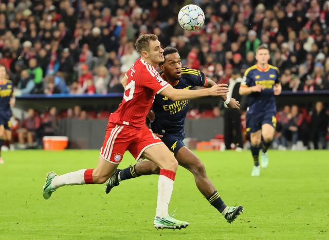 (261022) -- MUNICH, Oct. 22, 2026 (Xinhua) -- Josip Stanisic (L) of Bayern Munich vies with Jurrien Timber of Arsenal during the UEFA Champions League match between Bayern Munich and Arsenal in Munich, Germany, on Oct. 21, 2026. (Photo by Philippe Ruiz/Xinhua)