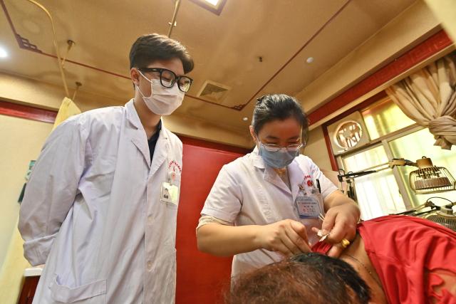 (261022) -- NANNING, Oct. 22, 2026 (Xinhua) -- Vietnamese student Lam Quang Duong (L) learns acupuncture under the guidance of his mentor, Dr. Chen Manghua, at the Second Affiliated Hospital of Guangxi University of Chinese Medicine in Nanning, south China's Guangxi Zhuang Autonomous Region, Oct. 21, 2026.
  Lam enrolled to the university in 2019 and completed his undergraduate studies in traditional Chinese medicine (TCM). Now he is pursuing master degree in acupuncture and tuina.
  Coming from a family of medical professionals, he chose a different path from his family members, most of whom practice Western medicine. His goal was to become the first TCM practitioner in his family. 
  Fluent in Chinese, Lam believes that TCM is not only a medical skill, but also a means of cross-border cultural exchange and heritage preservation. After graduation, he plans to return to Vietnam to practice medicine and continue his clinical and academic work in TCM.
  "I want to contribute to the medical development of China and Vietnam and help promote the exchange and preservation of traditional medicine between two countries," he said. (Xinhua/Lu Boan)