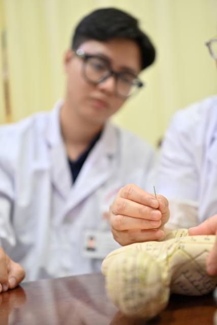 (261022) -- NANNING, Oct. 22, 2026 (Xinhua) -- Vietnamese student Lam Quang Duong (L) learns acupuncture under the guidance of his mentor, Dr. Chen Manghua, at the Second Affiliated Hospital of Guangxi University of Chinese Medicine in Nanning, south China's Guangxi Zhuang Autonomous Region, Oct. 21, 2026.
  Lam enrolled to the university in 2019 and completed his undergraduate studies in traditional Chinese medicine (TCM). Now he is pursuing master degree in acupuncture and tuina.
  Coming from a family of medical professionals, he chose a different path from his family members, most of whom practice Western medicine. His goal was to become the first TCM practitioner in his family. 
  Fluent in Chinese, Lam believes that TCM is not only a medical skill, but also a means of cross-border cultural exchange and heritage preservation. After graduation, he plans to return to Vietnam to practice medicine and continue his clinical and academic work in TCM.
  "I want to contribute to the medical development of China and Vietnam and help promote the exchange and preservation of traditional medicine between two countries," he said. (Xinhua/Lu Boan)