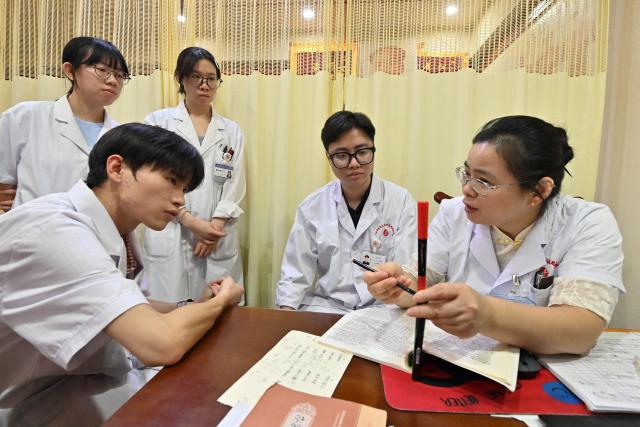 (261022) -- NANNING, Oct. 22, 2026 (Xinhua) -- Vietnamese student Lam Quang Duong (2nd R) and other students listen as Dr. Chen Manghua (1st R) explains acupuncture knowledge at the Second Affiliated Hospital of Guangxi University of Chinese Medicine in Nanning, south China's Guangxi Zhuang Autonomous Region, Oct. 21, 2026.
  Lam enrolled to the university in 2019 and completed his undergraduate studies in traditional Chinese medicine (TCM). Now he is pursuing master degree in acupuncture and tuina.
  Coming from a family of medical professionals, he chose a different path from his family members, most of whom practice Western medicine. His goal was to become the first TCM practitioner in his family. 
  Fluent in Chinese, Lam believes that TCM is not only a medical skill, but also a means of cross-border cultural exchange and heritage preservation. After graduation, he plans to return to Vietnam to practice medicine and continue his clinical and academic work in TCM.
  "I want to contribute to the medical development of China and Vietnam and help promote the exchange and preservation of traditional medicine between two countries," he said. (Xinhua/Lu Boan)