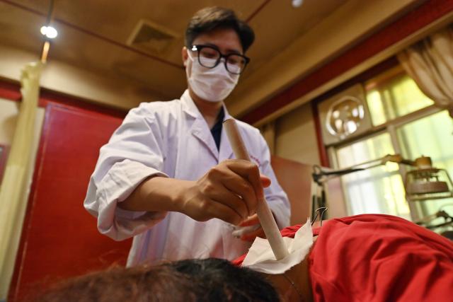 (261022) -- NANNING, Oct. 22, 2026 (Xinhua) -- Vietnamese student Lam Quang Duong treats a patient at the Second Affiliated Hospital of Guangxi University of Chinese Medicine in Nanning, south China's Guangxi Zhuang Autonomous Region, Oct. 21, 2026.
  Lam enrolled to the university in 2019 and completed his undergraduate studies in traditional Chinese medicine (TCM). Now he is pursuing master degree in acupuncture and tuina.
  Coming from a family of medical professionals, he chose a different path from his family members, most of whom practice Western medicine. His goal was to become the first TCM practitioner in his family. 
  Fluent in Chinese, Lam believes that TCM is not only a medical skill, but also a means of cross-border cultural exchange and heritage preservation. After graduation, he plans to return to Vietnam to practice medicine and continue his clinical and academic work in TCM.
  "I want to contribute to the medical development of China and Vietnam and help promote the exchange and preservation of traditional medicine between two countries," he said. (Xinhua/Lu Boan)