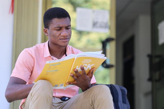 (261022) -- ACCRA, Oct. 22, 2026 (Xinhua) -- Photo taken on Oct. 14, 2026 shows Austin Elikem Afiawo, a final-year Chinese language and linguistics student learns Chinese at the Confucius Institute of the University of Ghana in Accra, Ghana. TO GO WITH "Feature: When a Ghanaian college student meets with Chinese traditional face-changing art" (Photo by Seth/Xinhua)