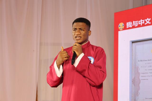 (261022) -- ACCRA, Oct. 22, 2026 (Xinhua) -- This file photo taken on May 22, 2026 shows Austin Elikem Afiawo, a final-year Chinese language and linguistics student delivers a speech during the Ghanaian finals of the 2026 Chinese Bridge competition in Kumasi, Ghana. TO GO WITH "Feature: When a Ghanaian college student meets with Chinese traditional face-changing art" (Photo by Seth/Xinhua)