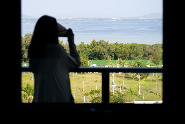 (261023) -- LINGSHUI, Oct. 23, 2026 (Xinhua) -- A woman takes photos at Lingshui Li'an International Education Innovation Pilot Zone in Lingshui Li Autonomous County, south China's Hainan Province, Oct. 22, 2026.
  As China's highland of educational opening up and innovation, Lingshui Li'an International Education Innovation Pilot Zone started construction in 2020. So far, over 30 renowned colleges and universities from home and abroad have settled in the pilot zone.
  The pilot zone is promoting as well as encouraging overseas high-level universities to run independent schools in the zone. It adopts an innovative model that all the universities have their own buildings, but share public facilities including the library, sports venues and public teaching buildings. (Xinhua/Xin Yuewei)