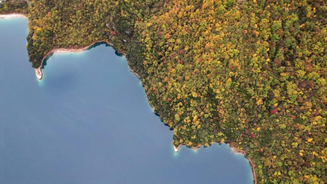 (261023) -- WENXIAN, Oct. 23, 2026 (Xinhua) -- An aerial drone photo taken on Oct. 22, 2026 shows the autumn scenery of Tianchi lake national forest park in Wenxian County, northwest China's Gansu Province. In late autumn, Tianchi lake national forest park is adorned with richly colored foliage. (Xinhua/Chen Bin)