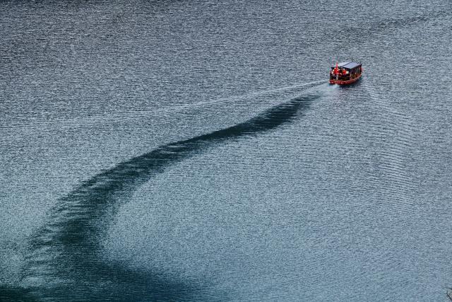 (261023) -- WENXIAN, Oct. 23, 2026 (Xinhua) -- This photo taken on Oct. 22, 2026 shows a tourist boat at Tianchi lake national forest park in Wenxian County, northwest China's Gansu Province. In late autumn, Tianchi lake national forest park is adorned with richly colored foliage. (Xinhua/Fei Maohua)