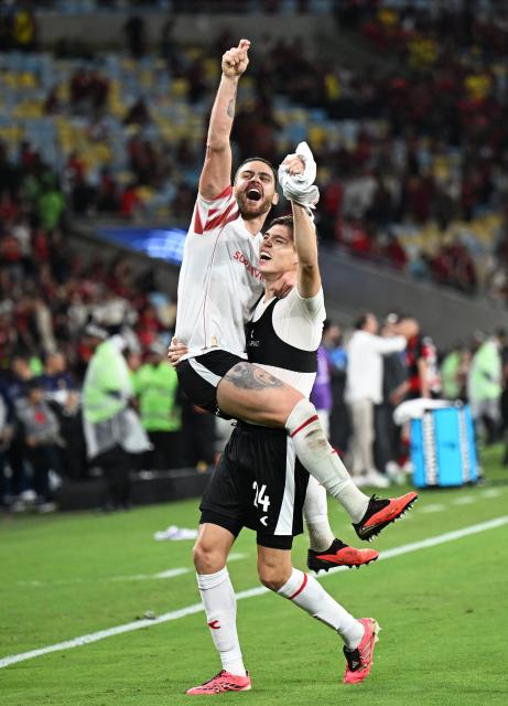 (261023) -- RIO DE JANEIRO, Oct. 23, 2026 (Xinhua) -- Leandro Gonzalez Pirez (top) and Tomas Palacios of Estudiantes de La Plata celebrate winning the penalty shootout of the second leg of the Copa Libertadores semifinal football match between Brazil's Flamengo and Argentina's Estudiantes de La Plata at the Maracana stadium in Rio de Janeiro, Brazil, Oct. 22, 2026. (Xinhua/Jin Haoyuan)