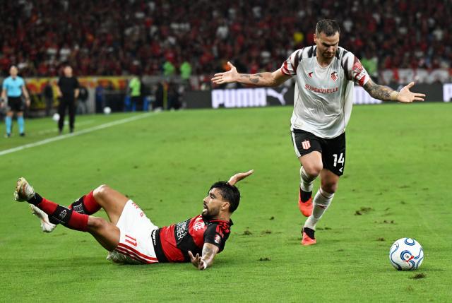 (261023) -- RIO DE JANEIRO, Oct. 23, 2026 (Xinhua) -- Lucas Paqueta (L) of Flamengo falls down during the second leg of the Copa Libertadores semifinal football match between Brazil's Flamengo and Argentina's Estudiantes de La Plata at the Maracana stadium in Rio de Janeiro, Brazil, Oct. 22, 2026. (Xinhua/Jin Haoyuan)