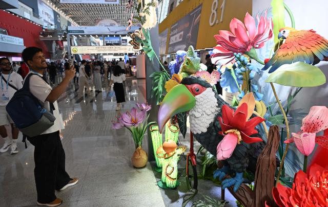 (261023) -- GUANGZHOU, Oct. 23, 2026 (Xinhua) -- A foreign buyer takes photos of decorative materials during the second phase of the 140th Canton Fair in Guangzhou, south China's Guangdong Province, Oct. 23, 2026. The second phase of the 140th China Import and Export Fair, also known as the Canton Fair, kicked off here on Friday. Themed "Quality Home Life," the second phase covered 515,000 square meters, with over 10,000 participating enterprises. (Xinhua/Deng Hua)
