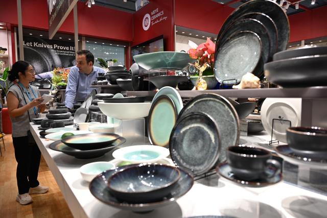 (261023) -- GUANGZHOU, Oct. 23, 2026 (Xinhua) -- A foreign buyer learns about ceramic products during the second phase of the 140th Canton Fair in Guangzhou, south China's Guangdong Province, Oct. 23, 2026. The second phase of the 140th China Import and Export Fair, also known as the Canton Fair, kicked off here on Friday. Themed "Quality Home Life," the second phase covered 515,000 square meters, with over 10,000 participating enterprises. (Xinhua/Deng Hua)