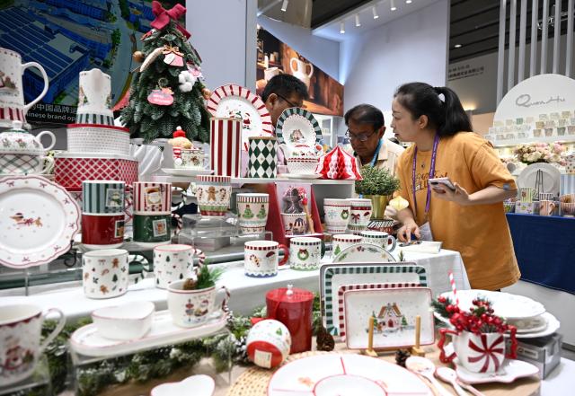 (261023) -- GUANGZHOU, Oct. 23, 2026 (Xinhua) -- A foreign buyer learns about ceramic products during the second phase of the 140th Canton Fair in Guangzhou, south China's Guangdong Province, Oct. 23, 2026. The second phase of the 140th China Import and Export Fair, also known as the Canton Fair, kicked off here on Friday. Themed "Quality Home Life," the second phase covered 515,000 square meters, with over 10,000 participating enterprises. (Xinhua/Deng Hua)