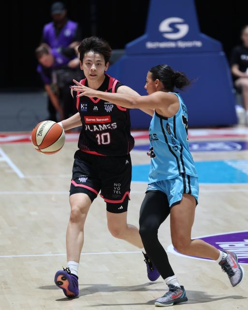 (261023) -- SYDNEY, Oct. 23, 2026 (Xinhua) -- Yang Shuyu (L) of Sydney Flames dribbles during the Women's National Basketball League (WNBL) basketball match between Sydney Flames and UC Capitals in Sydney, Australia, Oct. 23, 2026. (Xinhua/Gong Bing)