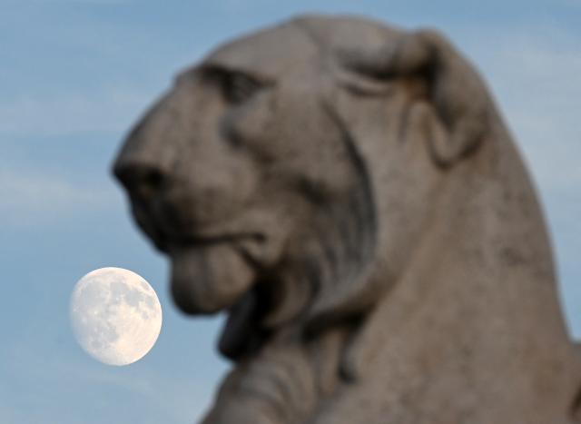 (261023) -- ROME, Oct. 23, 2026 (Xinhua) -- The moon is seen behind a statue in Piazza Venezia in Rome, Italy, Oct. 23, 2026. (Photo by Alberto Lingria/Xinhua)