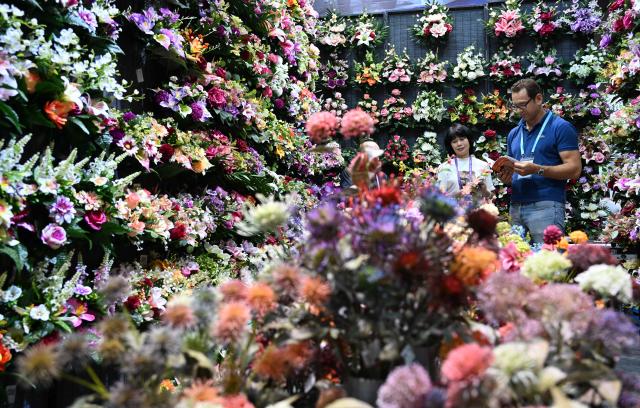 (261024) -- BEIJING, Oct. 24, 2026 (Xinhua) -- A foreign buyer learns about artificial flowers during the second phase of the 140th Canton Fair in Guangzhou, south China's Guangdong Province, Oct. 23, 2026. The second phase of the 140th China Import and Export Fair, also known as the Canton Fair, kicked off here on Friday. Themed "Quality Home Life," the second phase covered 515,000 square meters, with over 10,000 participating enterprises. (Xinhua/Deng Hua)