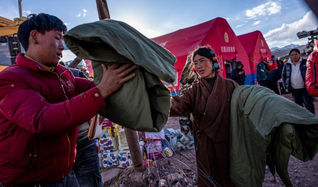 (261024) -- BEIJING, Oct. 24, 2026 (Xinhua) -- Villagers receive quilts at a temporary resettlement site of an earthquake-hit village in Maru Township of Baqen County, Nagqu City, southwest China's Xizang Autonomous Region, Oct. 23, 2026. China has allocated 50 million yuan (about 7.5 million U.S. dollars) in emergency disaster relief funds and earmarked another 30 million yuan for recovery efforts following a 7.0-magnitude earthquake in southwest China's Xizang Autonomous Region. The earthquake struck Baqen County of the city of Nagqu at 10:33 p.m. on Thursday. (Xinhua/Tenzin Nyida)