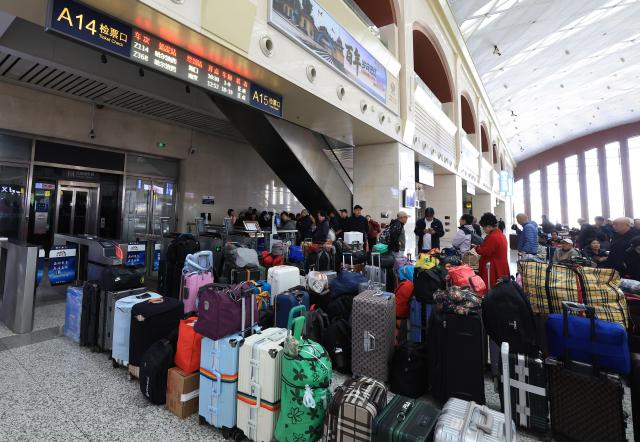 (261024) -- HARBIN, Oct. 24, 2026 (Xinhua) -- Passengers wait to check in before boarding the train Z114/111 at Harbin West Railway Station in Harbin, northeast China's Heilongjiang Province, Oct. 21, 2026.
  The train Z114/111, running between Harbin in northeast China's Heilongjiang Province and Haikou in south China's Hainan Province, has witnessed a surge of passengers before winter arrives in Heilongjiang.
  The train service, which takes about 48 hours to finish the 4,300-km-long journey, is popular among elderly travelers from northeast China heading south to escape the bitter winter cold. (Photo by Xu Shuai/Xinhua)