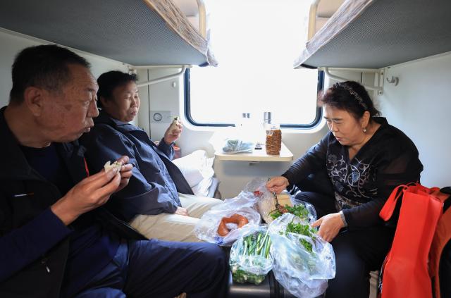 (261024) -- HARBIN, Oct. 24, 2026 (Xinhua) -- Passengers have meals aboard the train Z114/111 on Oct. 21, 2026.
  The train Z114/111, running between Harbin in northeast China's Heilongjiang Province and Haikou in south China's Hainan Province, has witnessed a surge of passengers before winter arrives in Heilongjiang.
  The train service, which takes about 48 hours to finish the 4,300-km-long journey, is popular among elderly travelers from northeast China heading south to escape the bitter winter cold. (Photo by Xu Shuai/Xinhua)
