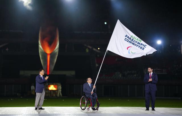 (261024) -- NAGOYA, Oct. 24, 2026 (Xinhua) -- Majid Rashed (C), president of the Asian Paralympic Committee, holds the flag of Asian Paralympic Committee during the closing ceremony of the Aichi-Nagoya Asian Para Games in Nagoya, Japan, Oct. 24, 2026. (Xinhua/Jia Haocheng)