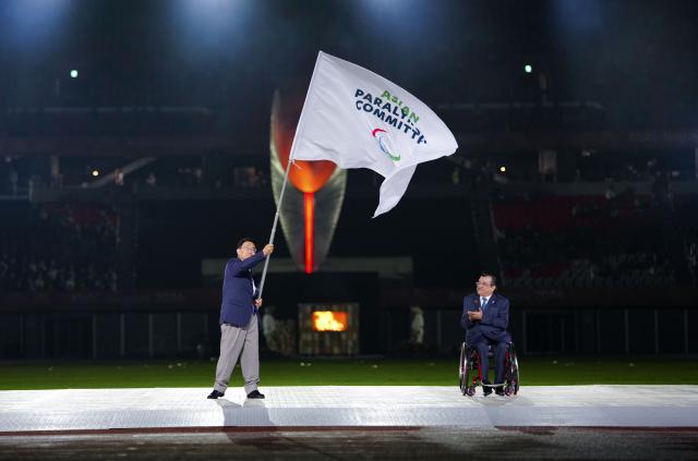 (261024) -- NAGOYA, Oct. 24, 2026 (Xinhua) -- Ohmura Hideaki (L), president of the Aichi-Nagoya Asian Games and Asian Para Games Organizing Committee, holds the flag of Asian Paralympic Committee as Majid Rashed, president of the Asian Paralympic Committee, applauds during the closing ceremony of the Aichi-Nagoya Asian Para Games in Nagoya, Japan, Oct. 24, 2026. (Xinhua/Jia Haocheng)
