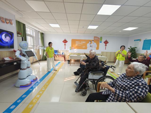 (261024) -- HEFEI, Oct. 24, 2026 (Xinhua) -- The elderly interact with an elderly care robot at a community in Baohe District of Hefei, east China's Anhui Province, Oct. 9, 2026. TO GO WITH "China Focus: China expands community-based care as population ages" (Xinhua/Guo Chen)