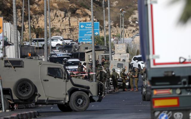(261024) -- HEBRON, Oct. 24, 2026 (Xinhua) -- Israeli soldiers stand guard at the northern checkpoint of the West Bank city of Hebron, Oct. 23, 2026. Israeli forces launched a military operation in the West Bank city of Hebron on Friday night, hours after Israeli leaders vowed to displace residents and carry out demolitions following a shooting attack near the city that killed two Israeli soldiers. (Photo by Mamoun Wazwaz/Xinhua)