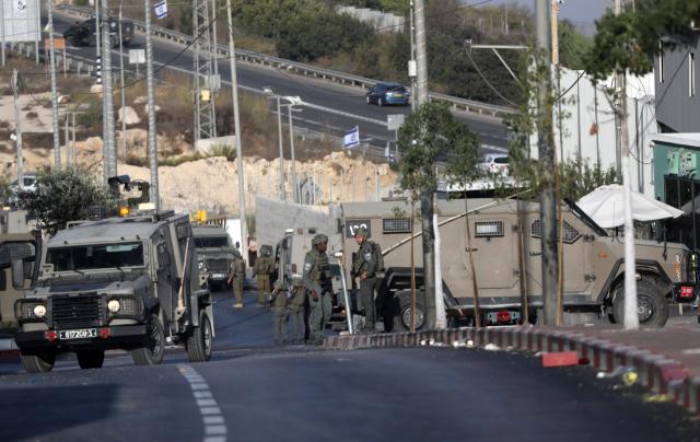 (261024) -- HEBRON, Oct. 24, 2026 (Xinhua) -- Israeli soldiers stand guard at the northern checkpoint of the West Bank city of Hebron, Oct. 23, 2026. Israeli forces launched a military operation in the West Bank city of Hebron on Friday night, hours after Israeli leaders vowed to displace residents and carry out demolitions following a shooting attack near the city that killed two Israeli soldiers. (Photo by Mamoun Wazwaz/Xinhua)