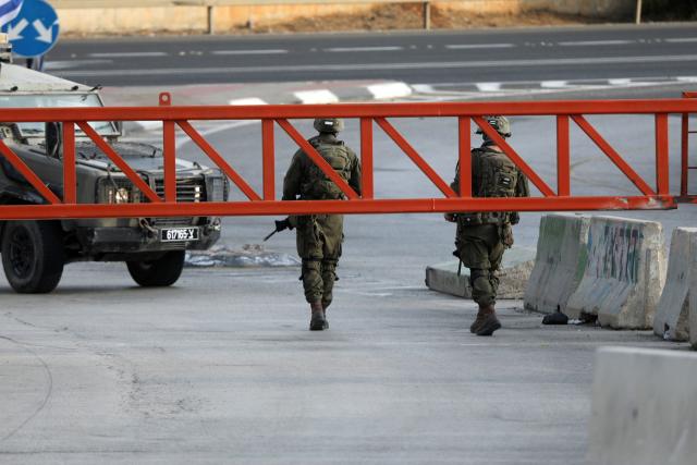 (261024) -- HEBRON, Oct. 24, 2026 (Xinhua) -- Israeli military forces are seen at an Israeli military checkpoint near the northern entrance to Hebron City, in the West Bank, on Oct. 24, 2026. Israeli forces launched a military operation in the West Bank city of Hebron on Friday night, hours after Israeli leaders vowed to displace residents and carry out demolitions following a shooting attack near the city that killed two Israeli soldiers.
  Prime Minister Benjamin Netanyahu also vowed to expand military operations and demolitions in Hebron, four days before Israel's parliamentary election. (Photo by Mamoun Wazwaz/Xinhua)