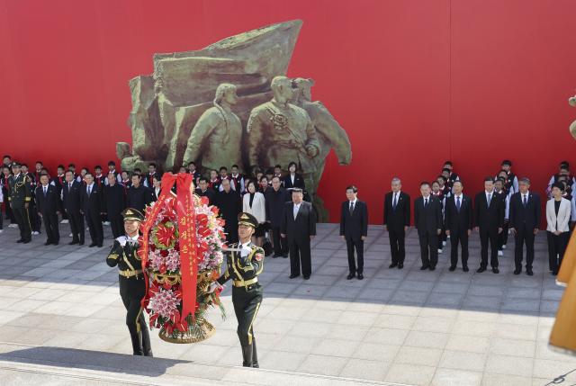 (261024) -- DANDONG, Oct. 24, 2026 (Xinhua) -- Wang Huning, a member of the Standing Committee of the Political Bureau of the Communist Party of China (CPC) Central Committee and chairman of the National Committee of the Chinese People's Political Consultative Conference, accompanies Kim Jong Un, general secretary of the Workers' Party of Korea and president of the State Affairs of the Democratic People's Republic of Korea (DPRK), to present a flower basket to the memorial tower at the square of the Memorial Hall of the War to Resist U.S. Aggression and Aid Korea, in Dandong, northeast China's Liaoning Province, Oct. 24, 2026. Wang on Saturday accompanied Kim on a visit to Dandong in northeast China's Liaoning Province and conveyed General Secretary of the CPC Central Committee and Chinese President Xi Jinping's cordial greetings and best wishes to Kim. (Xinhua/Yao Dawei)