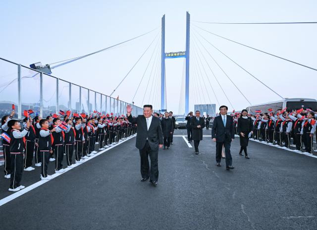 (261024) -- DANDONG, Oct. 24, 2026 (Xinhua) -- Wang Huning, a member of the Standing Committee of the Political Bureau of the Communist Party of China (CPC) Central Committee and chairman of the National Committee of the Chinese People's Political Consultative Conference, sees Kim Jong Un, general secretary of the Workers' Party of Korea and president of the State Affairs of the Democratic People's Republic of Korea (DPRK), off at the new China-DPRK Yalu River bridge when Kim leaves Dandong, northeast China's Liaoning Province, Oct. 24, 2026. Wang on Saturday accompanied Kim on a visit to Dandong in northeast China's Liaoning Province and conveyed General Secretary of the CPC Central Committee and Chinese President Xi Jinping's cordial greetings and best wishes to Kim. (Xinhua/Rao Aimin)