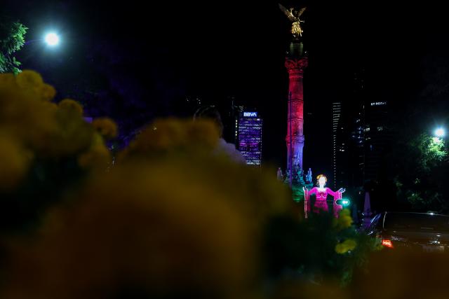 (261024) -- MEXICO CITY, Oct. 24, 2026 (Xinhua) -- This photo taken on Oct. 23, 2026 shows a Catrina-shaped light art installation near the Angel of Independence Monument in Mexico City, capital of Mexico. As the Day of the Dead approaches, giant light sculptures along Paseo de la Reforma in Mexico City, capital of Mexico, are illuminated. (Photo by Francisco Canedo/Xinhua)