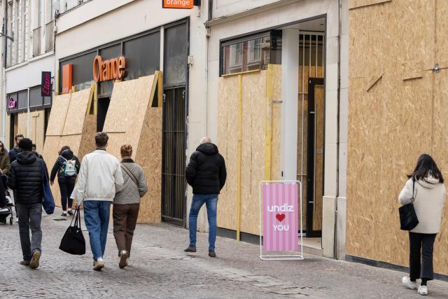 (261024) -- LILLE, Oct. 24, 2026 (Xinhua) -- People walk past boarded-up shops in Lille, France, Oct. 24, 2026. Around 410,000 people took part in a new round of protests across France on Saturday, French news channel BFM TV reported, citing the Interior Ministry. (Photo by Sebastien Courdji/Xinhua)