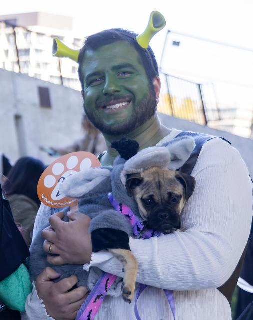 (261025) -- TORONTO, Oct. 25, 2026 (Xinhua) -- A dog and its owners pose for photos during "Howl'oween at the Bentway," a dog-and-owner costume contest, in Toronto, Canada, on Oct. 24, 2026. The annual event was held here on Saturday, bringing Halloween fun for dogs and their owners. (Photo by Zou Zheng/Xinhua)