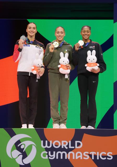 (261025) -- ROTTERDAM, Oct. 25, 2026 (Xinhua) -- Gold medalist Kaylia Nemour (C) of Algeria, silver medalist Helen Kevric (L) of Germany and bronze medalist Skye Blakely of the United States pose for a group photo during the awarding ceremony of the women's uneven bars event at the Artistic Gymnastics World Championships 2026 in Rotterdam, the Netherlands, Oct. 24, 2026. (Xinhua/Weng Xinyang)