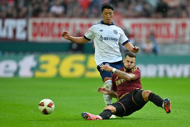 (261025) -- COLOGNE, Oct. 25, 2026 (Xinhua) -- Tom Krauss (bottom) of FC Cologne vies with Hwang Hee-Chan of FC Schalke 04 during the German first division Bundesliga football match between FC Cologne and FC Schalke 04 in Cologne, Germany, Oct. 24, 2026. (Photo by Ulrich Hufnagel/Xinhua)