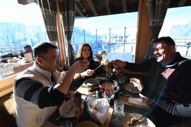 (261025) -- GENEVA, Oct. 25, 2026 (Xinhua) -- This file photo taken on Dec. 18, 2025 shows visitors enjoying Swiss cheese fondue in a restaurant at Grindelwald-First mountain in the canton of Bern, Switzerland. TO GO WITH "Feature: Taste of China's Wuyi Mountain at Switzerland's Grindelwald-First" (Xinhua/Lian Yi)
