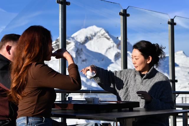 (261025) -- GENEVA, Oct. 25, 2026 (Xinhua) -- This file photo taken on Dec. 18, 2025 shows tourists tasting tea from China's Wuyi Mountain on a viewing platform at Grindelwald-First mountain in the canton of Bern, Switzerland. TO GO WITH "Feature: Taste of China's Wuyi Mountain at Switzerland's Grindelwald-First" (Xinhua/Lian Yi)