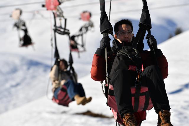 (261025) -- GENEVA, Oct. 25, 2026 (Xinhua) -- This file photo shows tourists riding on a zip line at Grindelwald-First mountain in the canton of Bern, Switzerland, Dec. 18, 2025. TO GO WITH "Feature: Taste of China's Wuyi Mountain at Switzerland's Grindelwald-First" (Xinhua/Lian Yi)