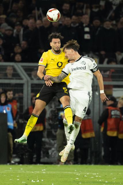 (261025) -- DORTMUND, Oct. 25, 2026 (Xinhua) -- Ramy Bensebaini (L) of Borussia Dortmund and Robin Koch of Eintracht Frankfurt head for the ball during the German first division Bundesliga football match between Borussia Dortmund and Eintracht Frankfurt in Dortmund, Germany, Oct. 24, 2026. (Photo by Joachim Bywaletz/Xinhua)