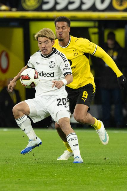 (261025) -- DORTMUND, Oct. 25, 2026 (Xinhua) -- Felix Nmecha (R) of Borussia Dortmund vies with Doan Ritsu of Eintracht Frankfurt during the German first division Bundesliga football match between Borussia Dortmund and Eintracht Frankfurt in Dortmund, Germany, Oct. 24, 2026. (Photo by Joachim Bywaletz/Xinhua)