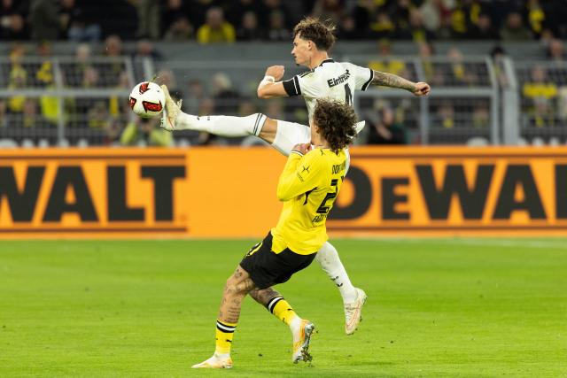 (261025) -- DORTMUND, Oct. 25, 2026 (Xinhua) -- Fabio Silva (bottom) of Borussia Dortmund vies with Robin Koch of Eintracht Frankfurt during the German first division Bundesliga football match between Borussia Dortmund and Eintracht Frankfurt in Dortmund, Germany, Oct. 24, 2026. (Photo by Joachim Bywaletz/Xinhua)