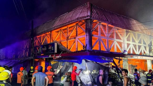 (261025) -- SORSOGON, Oct. 25, 2026 (Xinhua) -- People gather outside a burning public market in Sorsogon city of southern Luzon, the Philippines, on Oct. 25, 2026. Five people have been confirmed dead after a fire in a public market here on Saturday night, local media reported Sunday. (Sorsogon Public Information Office/Handout via Xinhua)