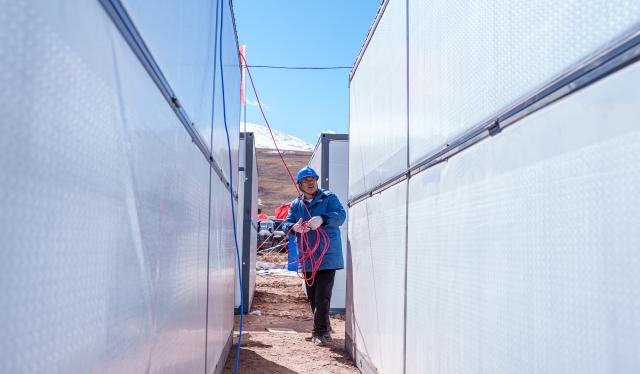 (261025) -- BAQEN, Oct. 25, 2026 (Xinhua) -- An electric worker installs power supply lines at a resettlement site of a quake-hit village in Maru Township of Baqen County, Nagqu City, southwest China's Xizang Autonomous Region, Oct. 25, 2026. Power supply lines are being installed for prefabricated houses in the quake-hit Baqen County. According to the State Grid, power connection supplies for 2,724 tents and 2,400 prefabricated houses have been deployed to meet electricity connection needs in the quake-hit area. (Xinhua/Tenzin Nyida)