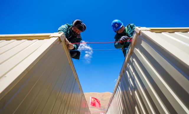(261025) -- BAQEN, Oct. 25, 2026 (Xinhua) -- Electric workers install power supply lines at a resettlement site of a quake-hit village in Maru Township of Baqen County, Nagqu City, southwest China's Xizang Autonomous Region, Oct. 25, 2026. Power supply lines are being installed for prefabricated houses in the quake-hit Baqen County. According to the State Grid, power connection supplies for 2,724 tents and 2,400 prefabricated houses have been deployed to meet electricity connection needs in the quake-hit area. (Xinhua/Tenzin Nyida)