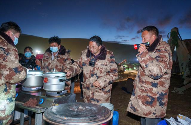 (261025) -- BAQEN, Oct. 25, 2026 (Xinhua) -- Du Guoping (2nd R) checks a pressure cooker at a temporary shelter in Maru Township of Baqen County, Nagqu City, southwest China's Xizang Autonomous Region, Oct. 24, 2026. After a 7.0-magnitude earthquake struck Baqen County in Nagqu, southwest China's Xizang Autonomous Region, on Thursday, Du Guoping, owner of a dumpling restaurant in Xigaze, postponed the opening of his two new restaurants and headed to the disaster zone with his staff.
  "It took only about 10 minutes to make the decision that we would go to Baqen and cook dumplings for earthquake-affected residents," Du said.
  The team loaded more than 1,500 kilograms of dumplings onto vehicles and set off from Xigaze at midnight on the night of the earthquake. 
  Upon arrival, Du and his staff set up cooking equipment and prepared dumplings for rescue workers and affected residents.
"Make sure everyone gets enough dumplings, and give children a couple more," Du kept telling his staff.
  Du and his staff did not eat any of the dumplings themselves. After a full day of cooking, they had some instant noodles -- their only meal of the day. At night, the six team members of Du squeezed into two vehicles to rest.
  "We will cook all the dumplings we brought," Du said. "We feel honored to be able to contribute in our own way." (Xinhua/Tenzin Nyida)
